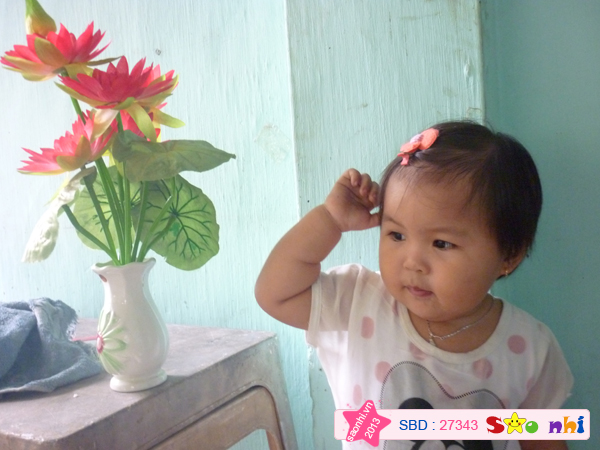 Bé tạo dáng bên hoa